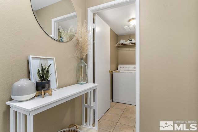 laundry room with light tile patterned flooring and washer / dryer