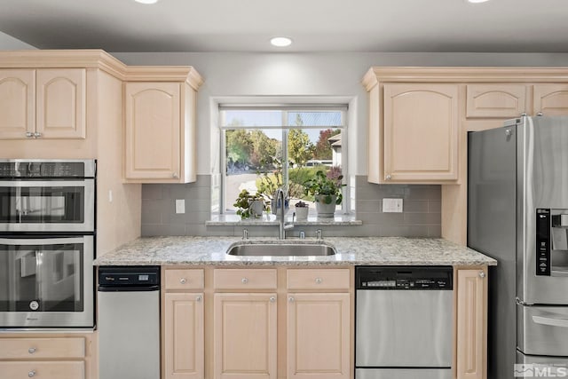 kitchen with light brown cabinetry, sink, and stainless steel appliances