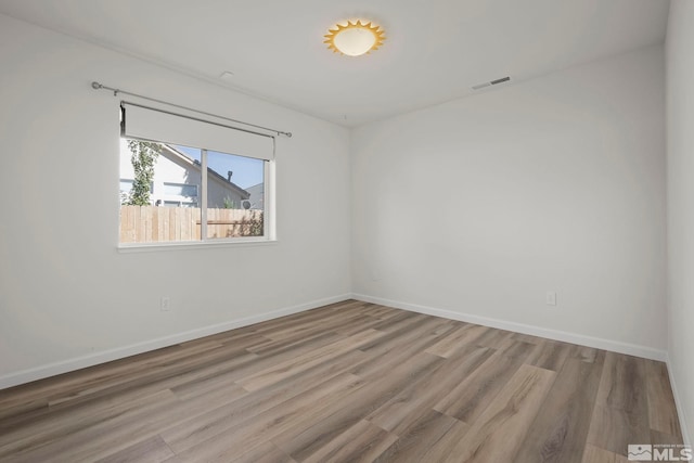 unfurnished room with hardwood / wood-style flooring