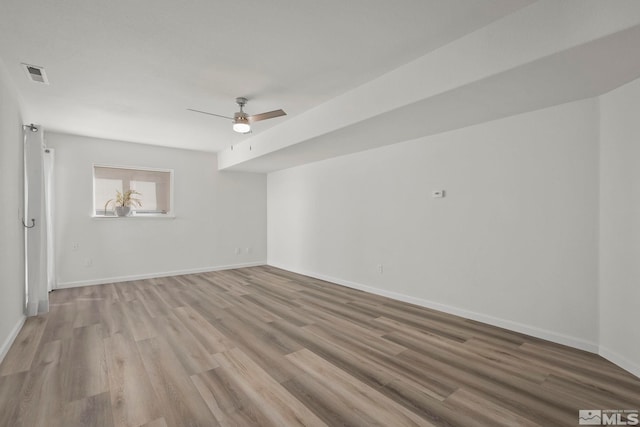 spare room with ceiling fan and light wood-type flooring