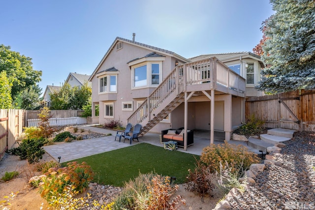 back of property featuring a wooden deck, an outdoor hangout area, a patio area, and a yard