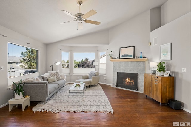 living room featuring a tiled fireplace, plenty of natural light, and dark hardwood / wood-style flooring