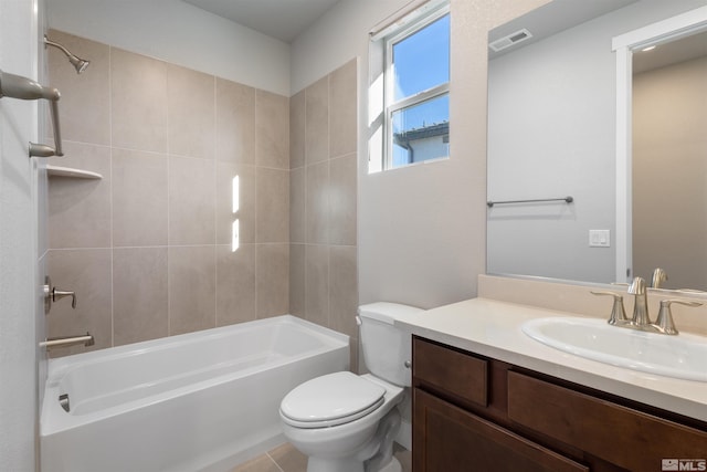 full bathroom featuring vanity, tiled shower / bath combo, and toilet