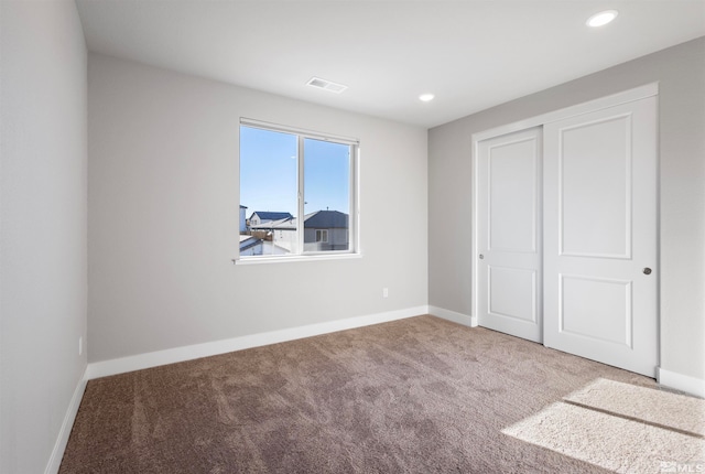 unfurnished bedroom featuring carpet and a closet