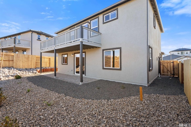 back of house featuring a balcony and a patio