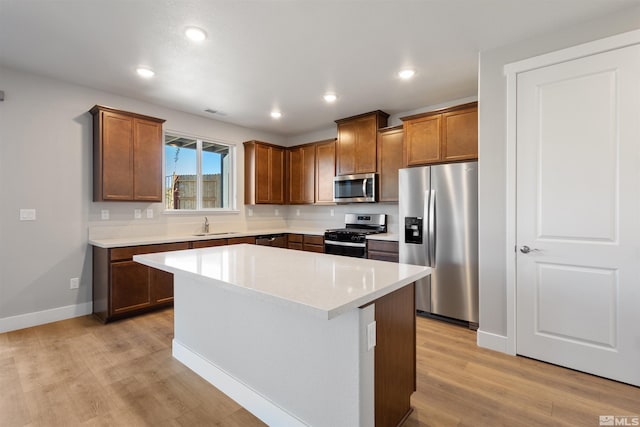 kitchen with a center island, light hardwood / wood-style flooring, stainless steel appliances, and sink