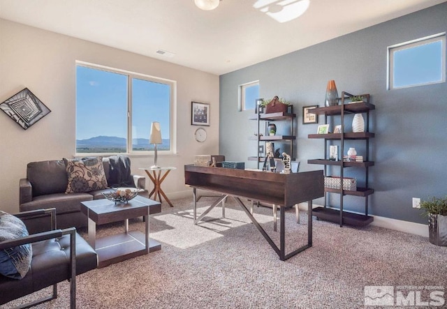 carpeted home office featuring a mountain view and plenty of natural light