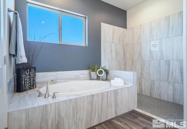 bathroom featuring wood-type flooring and plus walk in shower