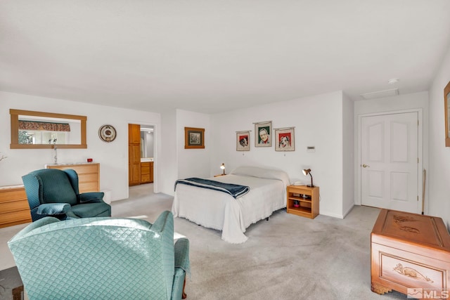 bedroom featuring light colored carpet and ensuite bathroom