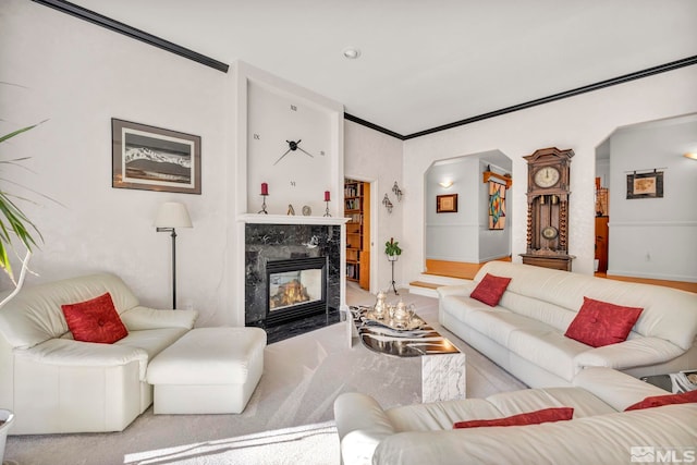 living room with ornamental molding and a high end fireplace