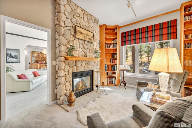 carpeted living room with ornamental molding and a fireplace