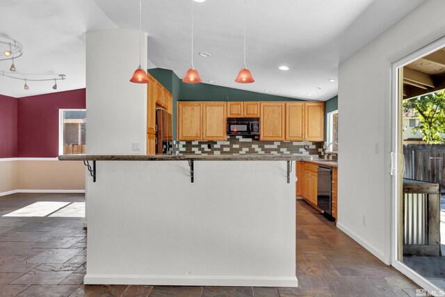 kitchen with black appliances, decorative backsplash, a breakfast bar area, and vaulted ceiling