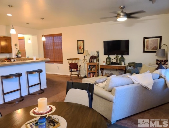 living room featuring dark colored carpet and ceiling fan