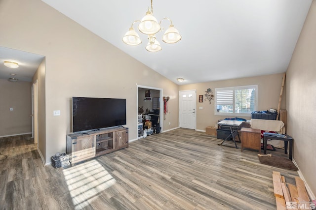 living room featuring wood-type flooring, a notable chandelier, and high vaulted ceiling