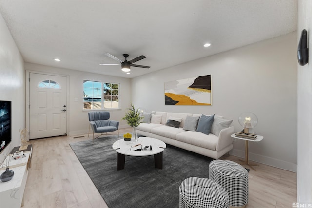 living room with ceiling fan and light hardwood / wood-style floors