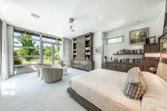 carpeted bedroom with a wall of windows, ceiling fan, and french doors