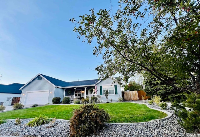 ranch-style house featuring a garage, a front yard, and covered porch