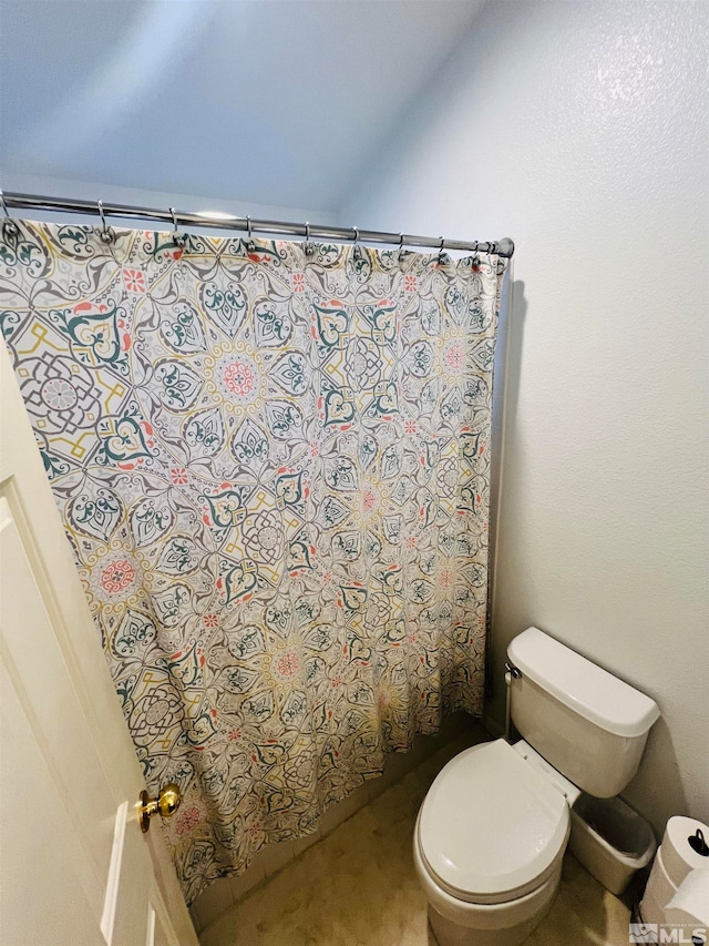 bathroom featuring toilet and a shower with shower curtain