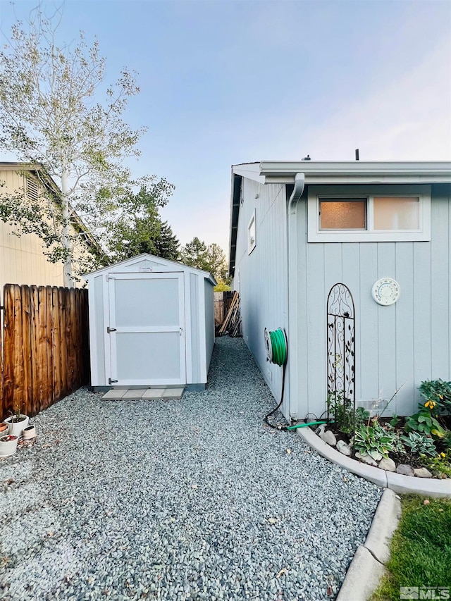 view of side of property with a storage shed and a patio