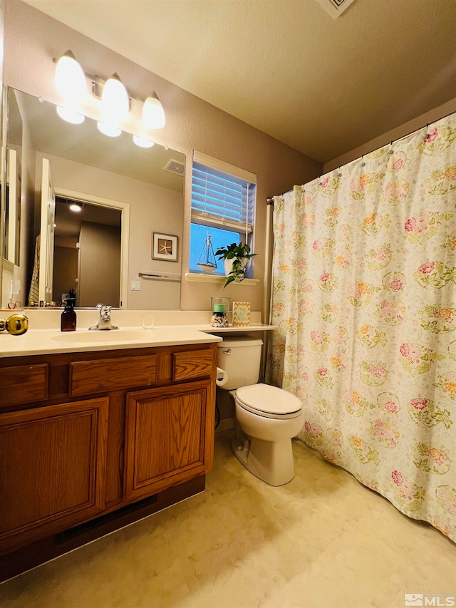 bathroom with a shower with curtain, vanity, toilet, and a textured ceiling