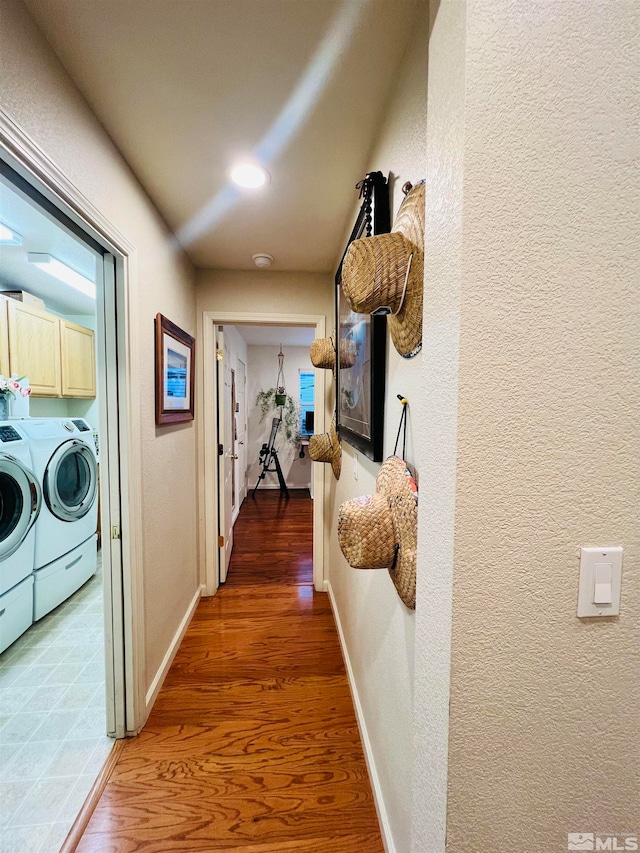 corridor with wood-type flooring and washer and dryer