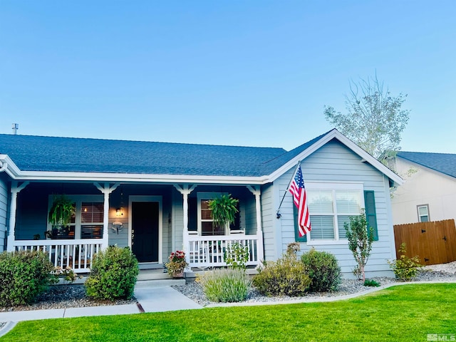 single story home featuring a front lawn and covered porch