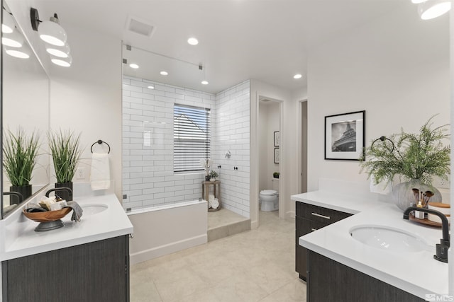bathroom featuring two vanities, toilet, a sink, and walk in shower