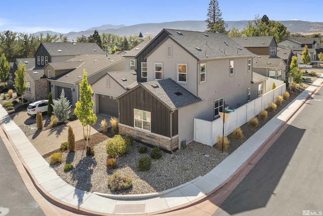 exterior space with a mountain view, a residential view, stone siding, and board and batten siding