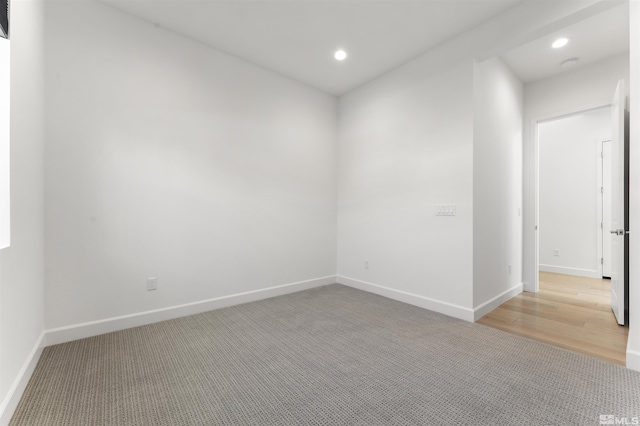 unfurnished room with baseboards, recessed lighting, and light colored carpet