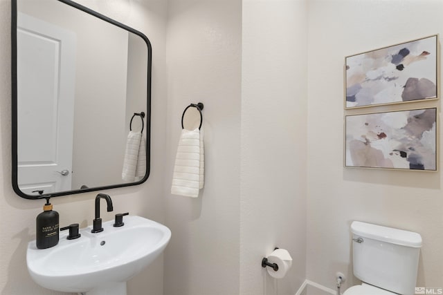 half bathroom featuring a sink and toilet