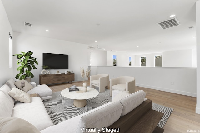 living area featuring light wood-style flooring, visible vents, and recessed lighting