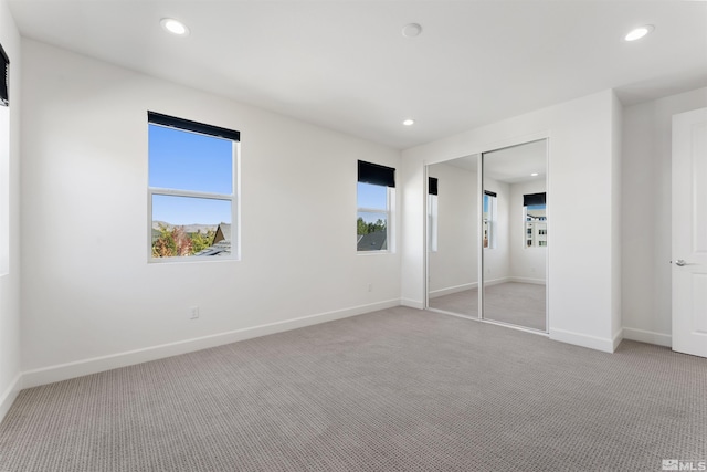 unfurnished bedroom with baseboards, recessed lighting, and light colored carpet