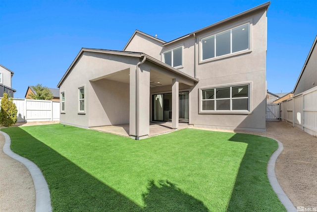 back of house featuring ceiling fan, a lawn, and a patio area