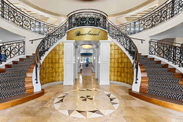 entrance foyer featuring ornate columns and a high ceiling