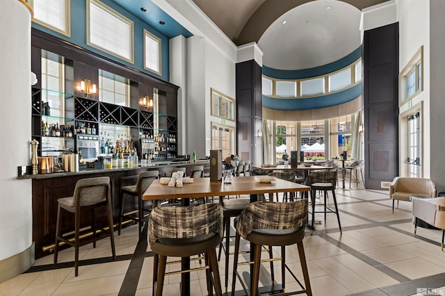 tiled dining area with bar and a high ceiling