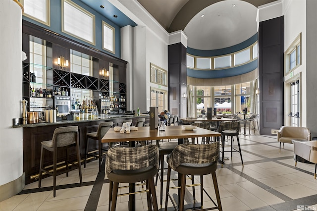 dining area featuring a community bar and a high ceiling