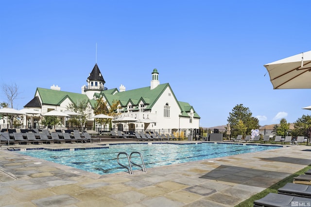 community pool with fence and a patio area