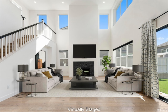 living room with a towering ceiling and light hardwood / wood-style floors