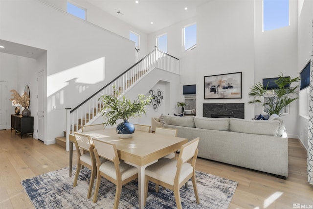 dining space featuring light wood-style floors, stairway, and plenty of natural light