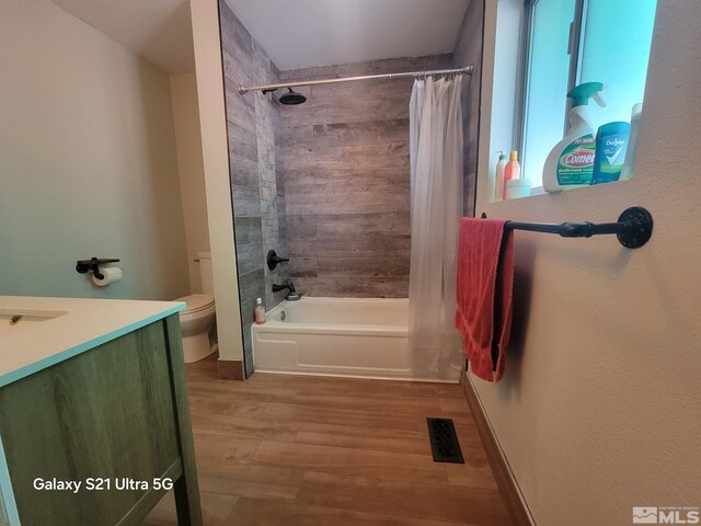 full bathroom featuring wood-type flooring, vanity, toilet, and shower / tub combo