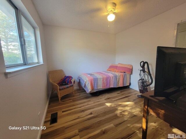 bedroom featuring a textured ceiling, hardwood / wood-style flooring, and ceiling fan