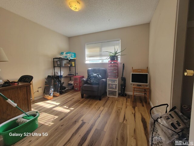 home office featuring hardwood / wood-style floors and a textured ceiling