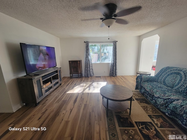 living room featuring a textured ceiling, hardwood / wood-style flooring, and ceiling fan