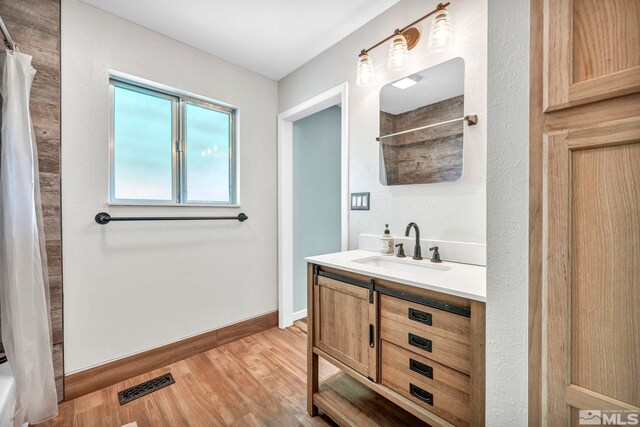 bathroom featuring shower / tub combo with curtain, wood-type flooring, and vanity