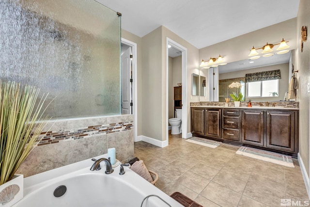 bathroom featuring a tub, toilet, vanity, and tile patterned floors