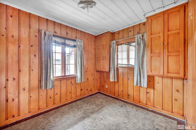 spare room with light colored carpet and wood walls