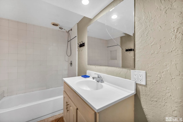 bathroom featuring vanity and tiled shower / bath