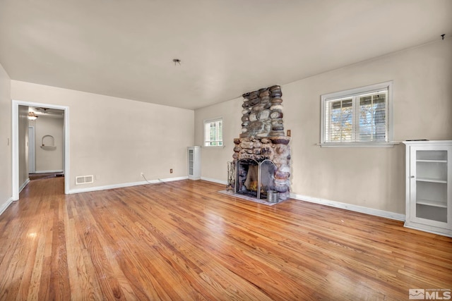 unfurnished living room with a wealth of natural light, light hardwood / wood-style floors, and a fireplace