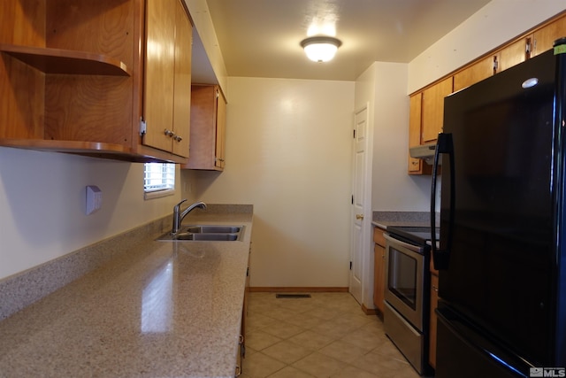 kitchen with light tile patterned floors, electric range, sink, and black fridge