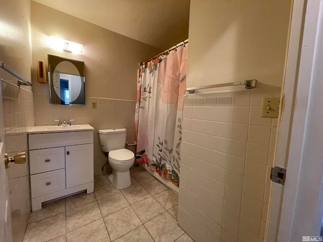 bathroom with vanity, curtained shower, tile patterned floors, tile walls, and toilet